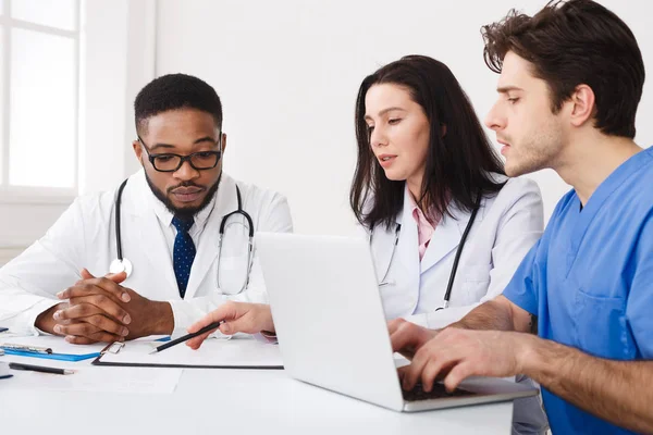Medizinisches Team diskutiert Berichte mit Laptop bei Treffen — Stockfoto