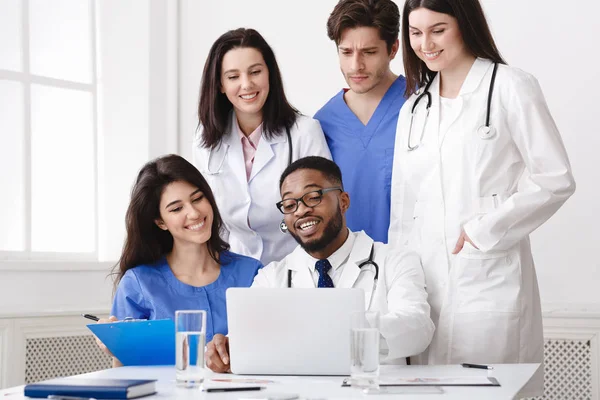 Grupo multinacional de médicos olhando no laptop — Fotografia de Stock