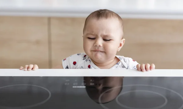Baby boy reaching to hot electric stove — Stock Photo, Image