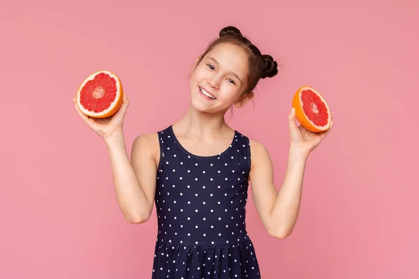 カットグレープフルーツの半分と笑顔を持つ小さな女の子 — ストック写真