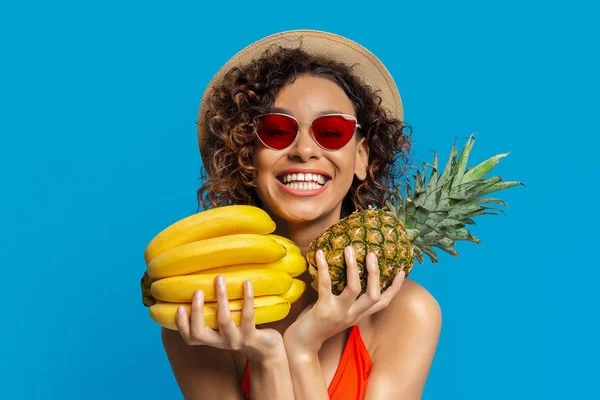 Glückliche Afrikanerin umarmt frische tropische Früchte — Stockfoto