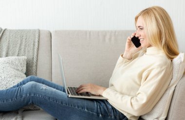 Telefonla konuşan kadın, dizüstü bilgisayar kullanan.