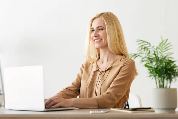 Исполнительная финансовая женщина работает на ноутбуке в офисе — стоковое фото