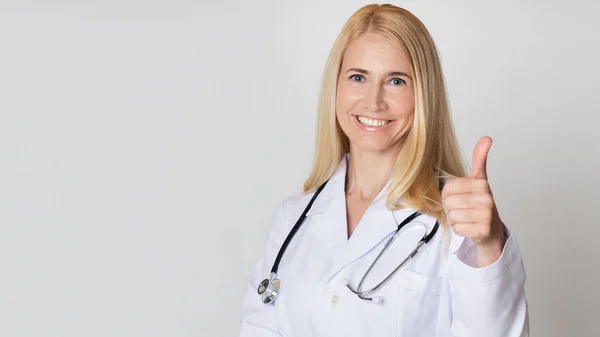 Medicinsk arbetare med stetoskop leende, visar tummen upp — Stockfoto
