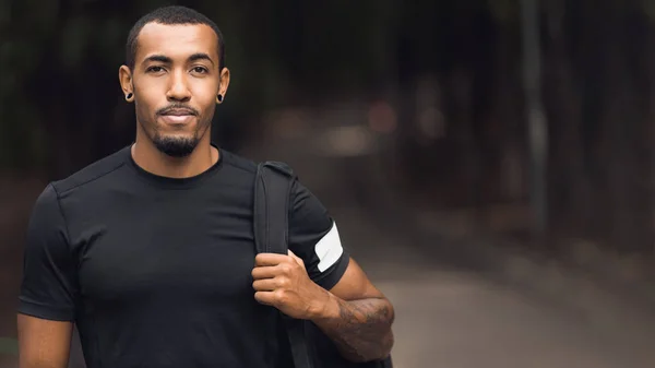 Sportlicher Mann posiert nach dem Training, trägt schwarzes T-Shirt — Stockfoto