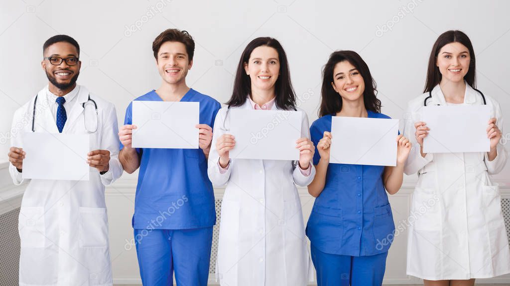 Doctors And Interns Holding Empty Papers, Standing In Hospital