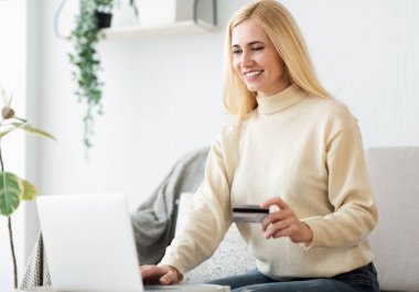 Mutlu kadın evde online alışveriş yapıyor.