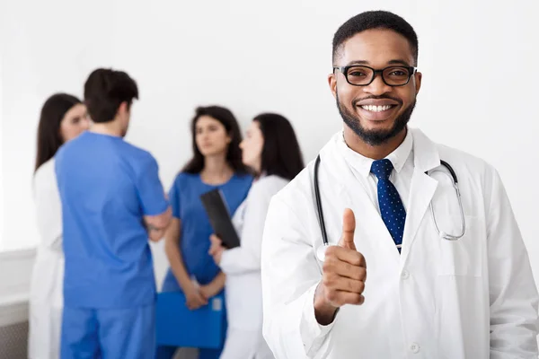 Médico africano profesional mostrando pulgar hacia arriba en el hospital — Foto de Stock