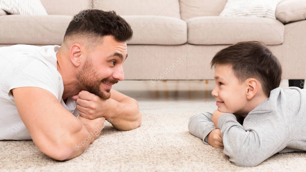 Cute boy and handsome man looking at each other