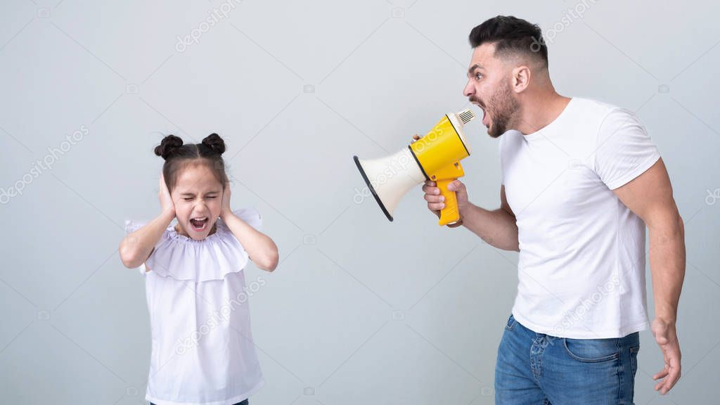 Father with megaphone screaming at daughter closing ears
