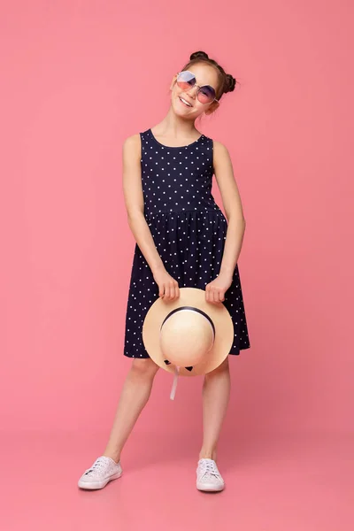 Menina bonito no vestido de verão e óculos de sol posando com chapéu de vime — Fotografia de Stock
