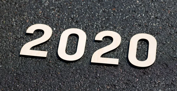 Close up of wooden 2020 numbers on black asphalt — Stock Photo, Image