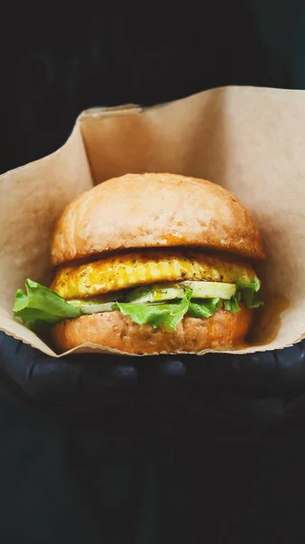 Vegan σνακ - burger με ετικέτα κειμένου στα χέρια — Φωτογραφία Αρχείου
