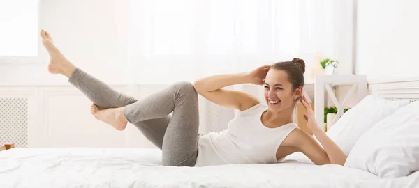 Sabah egzersizi. Yatakta Abs Egzersiz Yapan Kadın — Stok fotoğraf