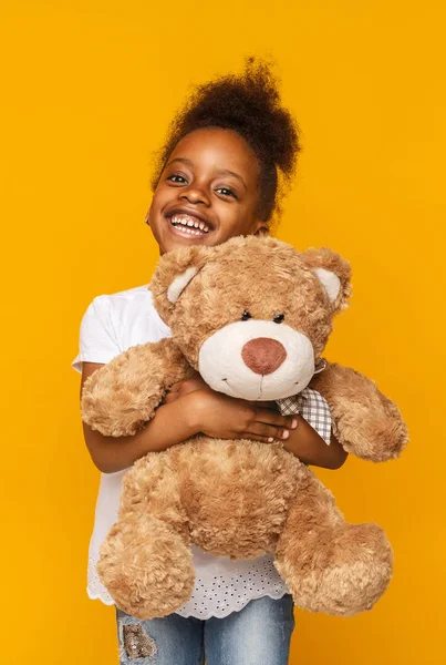 Schattige Afro-Amerikaanse kind knuffelen teddybeer en glimlachend — Stockfoto