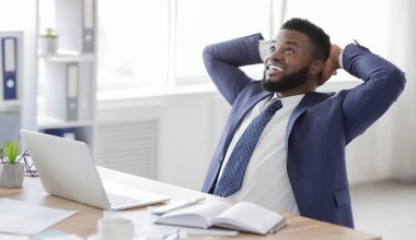 Genç Afrikalı iş adamı iş yerinde rahatlıyor.