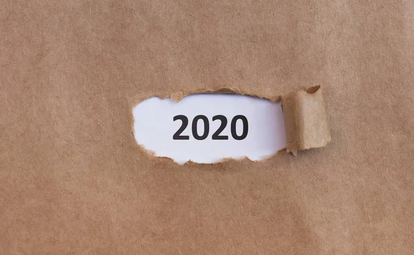 2020 white text under brown old torn paper — Stock Photo, Image