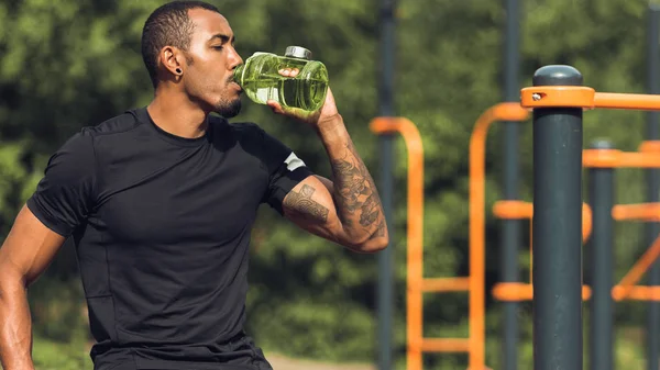 Homem desportivo água potável após o treino ao ar livre — Fotografia de Stock