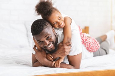 Afrikalı Amerikalı adam küçük kızı ile kucaklayan