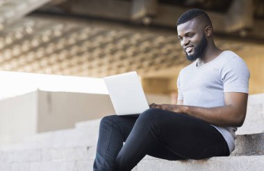 Gülümseyen afro-amerikan adam onun laptop kodlama