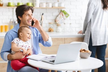 Çalışma From Home dizüstü bilgisayarda bebek oğluyla baba