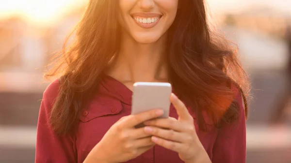 Chica joven charlando en las redes sociales en el teléfono inteligente al aire libre —  Fotos de Stock