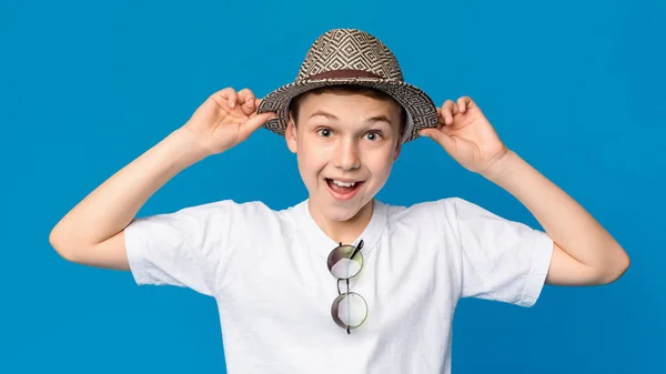 Cheerful teenager smiling in wicker hat, blue panorama background — Stock Photo, Image
