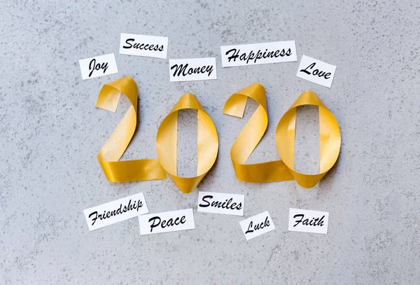 Best new year wishes with gold ribbon 2020 text on grey wall — Stock Photo, Image