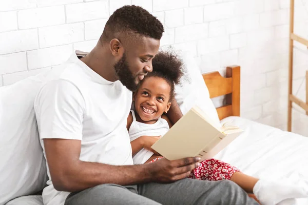 Afrikanischer Amerikaner liest seiner kleinen Tochter Märchen vor — Stockfoto