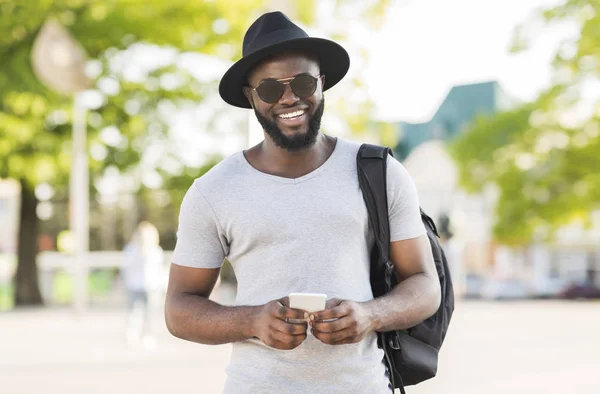 Sonriente chico afroamericano planeando su viaje con mapas — Foto de Stock