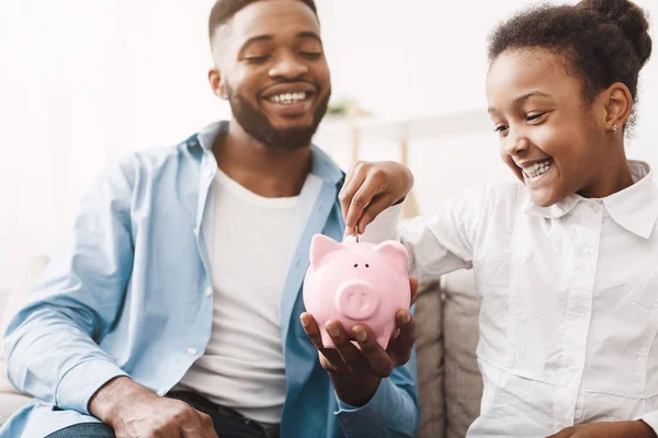 Personliga besparingar. Little afro Girl sätta pengar till Piggybank — Stockfoto