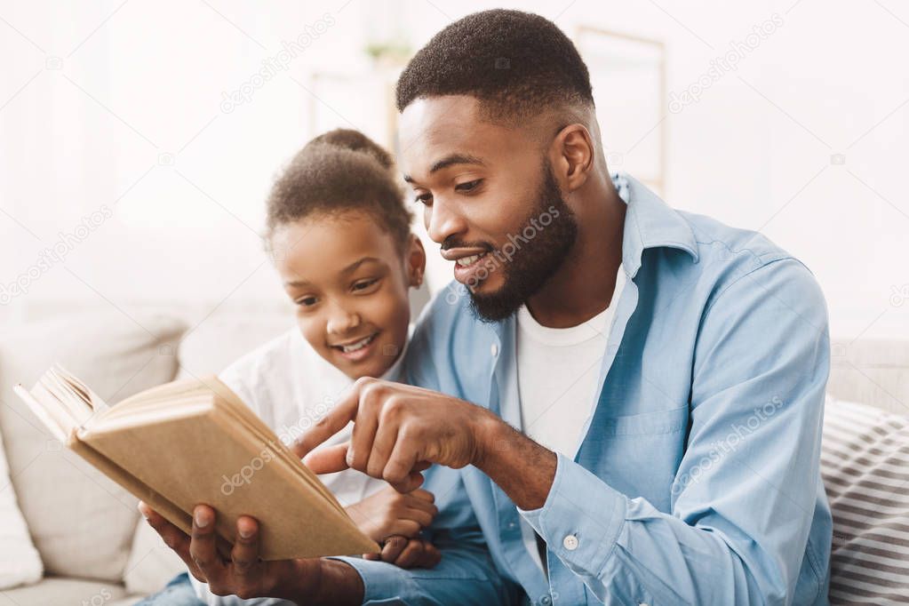 African Dad And Daughter Reading Book Together At Home