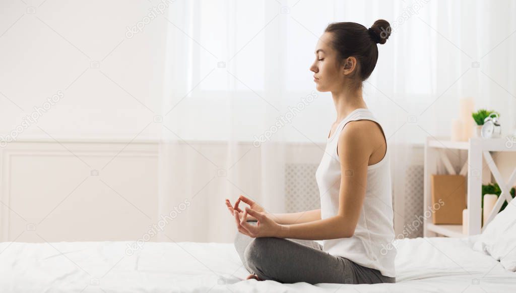 Morning Meditation. Woman Practicing Yoga On Bed