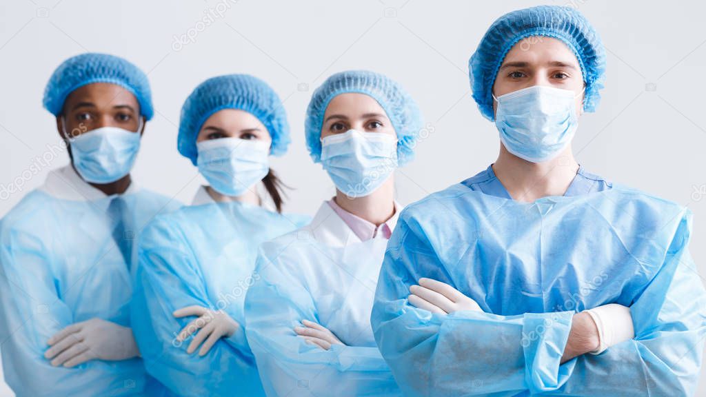 Surgeons Team. Doctors Wearing Protective Uniform, Look At Camera