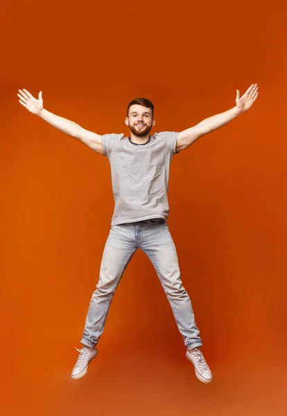 Young millennial man jumping with open hands — 스톡 사진