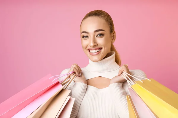 Gelukkig winkelen. Meisje met kleurrijke tassen, roze achtergrond — Stockfoto