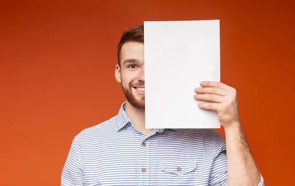 Jonge lachende man bedekt de helft van zijn gezicht naast wit laken — Stockfoto