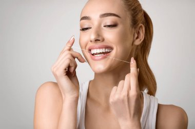 Ağız Hijyeni. Diş Ipi Kullanan Gülümseyen Kadın