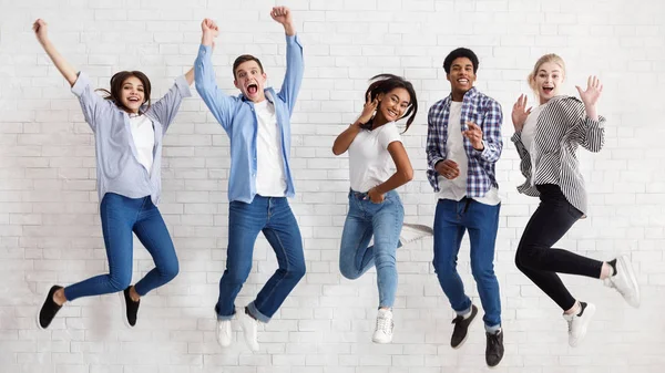 Estudiantes felices saltando sobre fondo blanco, exámenes aprobados —  Fotos de Stock