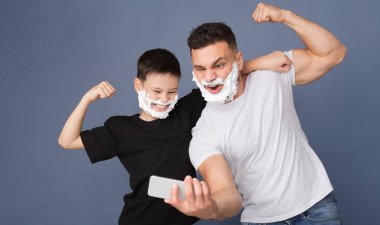 Baba ve oğlu birlikte eğleniyor, tıraş köpüğüyle poz