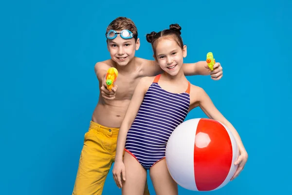 Веселые мальчик и девочка наслаждаются отдыхом с пляжными игрушками — стоковое фото