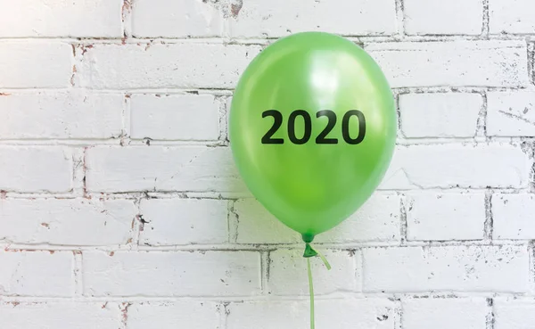 Close up of green balloon with 2020 text on white