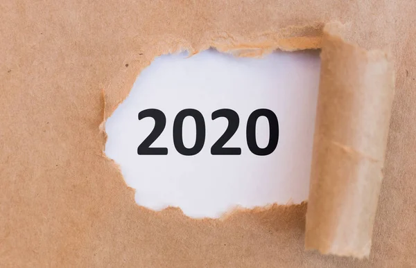 Close up of 2020 black text under torned brown paper — Stock Photo, Image