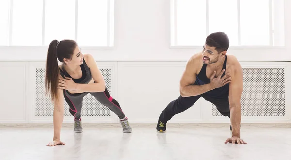 Junges, fittes Paar steht mit einer Hand in Planke — Stockfoto