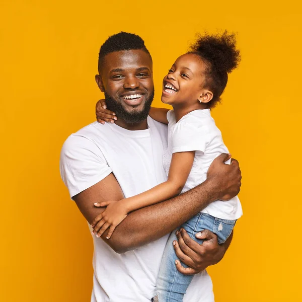 Šťastný Afričan objímá svou pozitivní dcerku — Stock fotografie