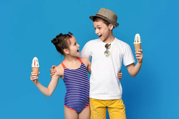 Возбужденные маленький мальчик и девочка обнимаются с рожками мороженого — стоковое фото