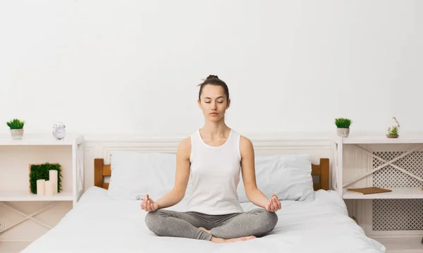 Concepto de meditación. Mujer practicando yoga en la cama — Foto de Stock