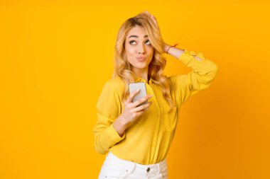 Düşünceli kadın Cellphone kullanarak ve yukarı bakıyor