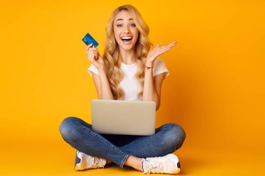 Şaşırttı kadın laptop ve kredi kartı Ile oturuyor