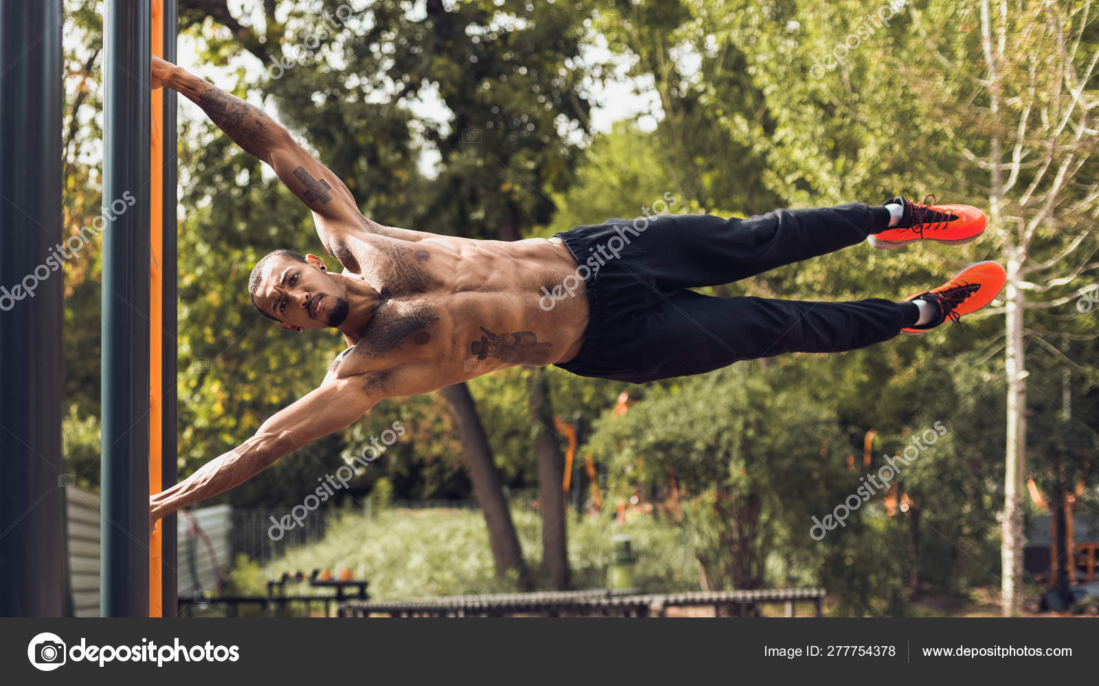 Hombre fuerte practicando el ejercicio de la bandera humana